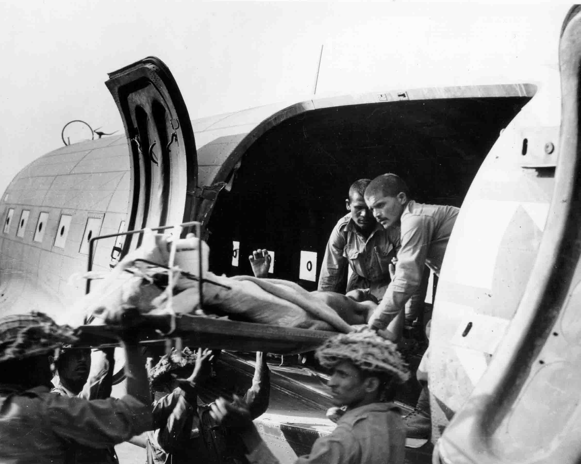 Stretcher-bearers carefully lift seriously wounded out of a USAAF C-47 of the 1st Air Commando Group, Burma, 1944 (RAFM PC71/19/1540)