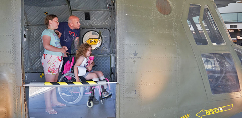 Family with child in a wheelchair in the back of the Chinook in H6