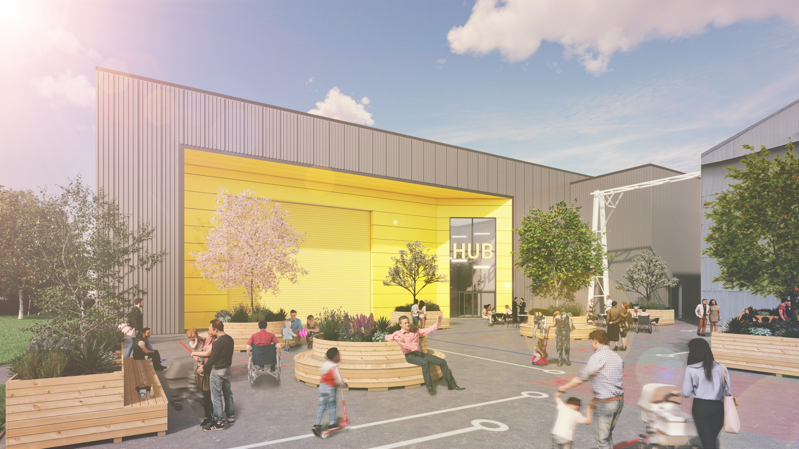 An exterior of a warehouse with a yellow front, outdoor seating, trees, and people engaging in various activities under a sunny sky.