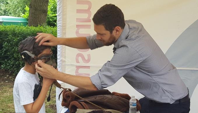 A young child trying on a RAF helmet