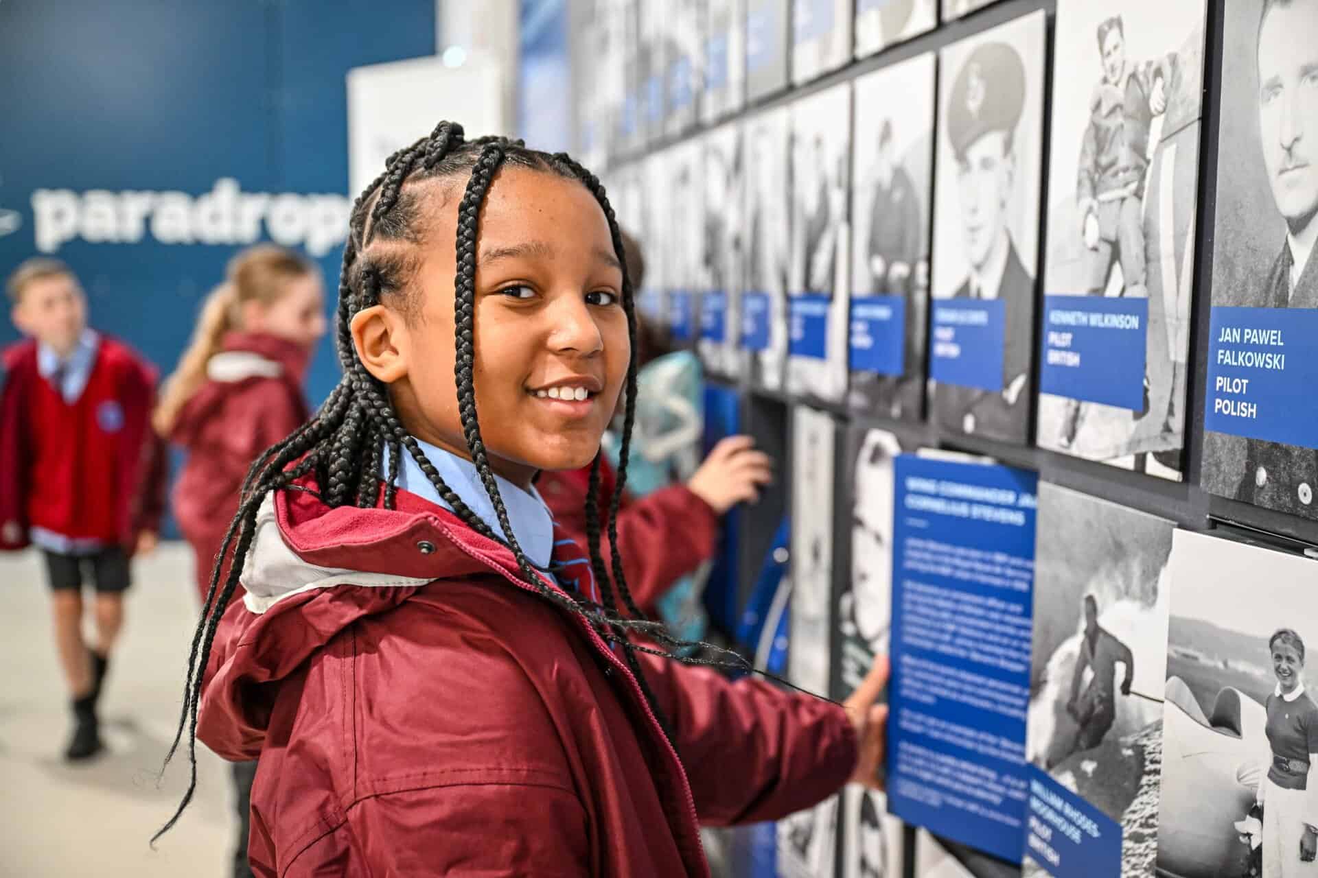 The image depicts a group of students walking around the Royal Air force Museum and past some aircraft.