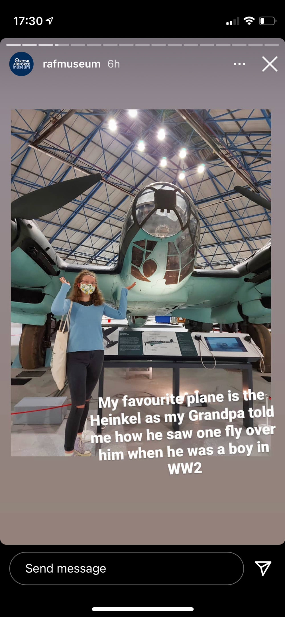 A member of our Youth Panel standing underneath our Heinkel with their arms raised up