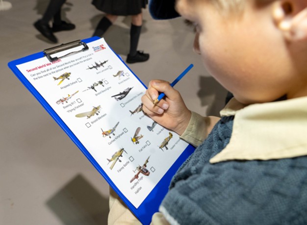 Child filling in answers to a RAF Museum trail activity.