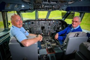 Two men sit in the VC10 cockpit, surrounded by flight controls.