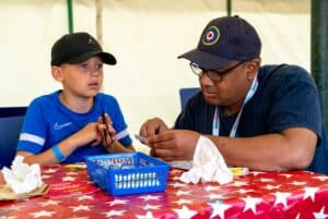 Volunteer Eric helps in the Airfix Make and Take tent at the Hendon Pageant