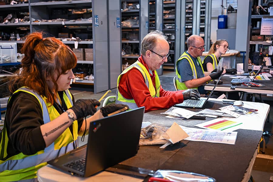 Volunteers smiling beside an aircraft cockpit.